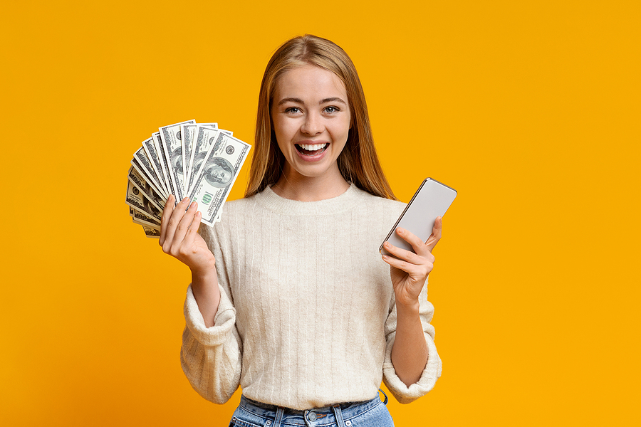 Woman holding a phone and money.