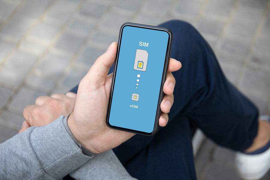 Person sitting with legs crossed holding a mobile phone