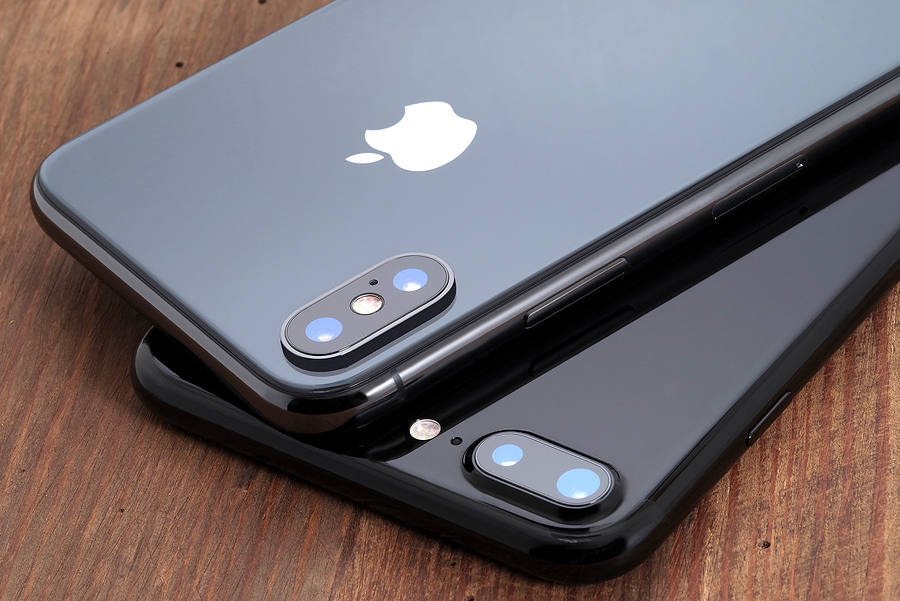 Two gray Apple iPhones laying face down.