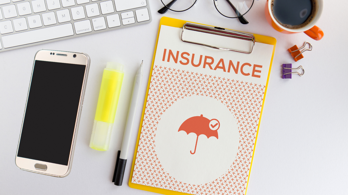 mobile phone next to clipboard with paper saying Insurance