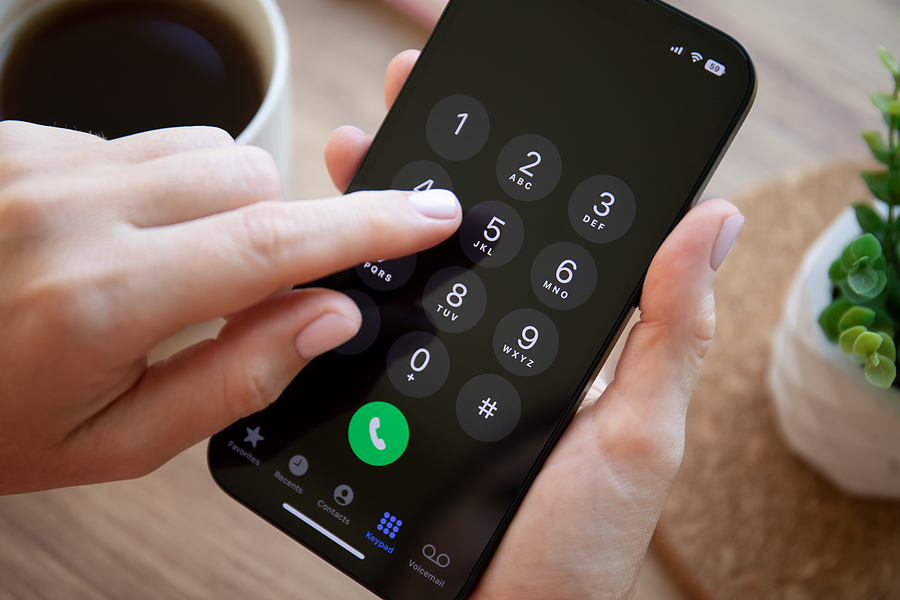 Finger pushing keys on an iPhone 14