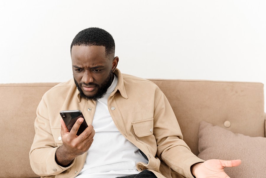 man on couch with cell phone in hand